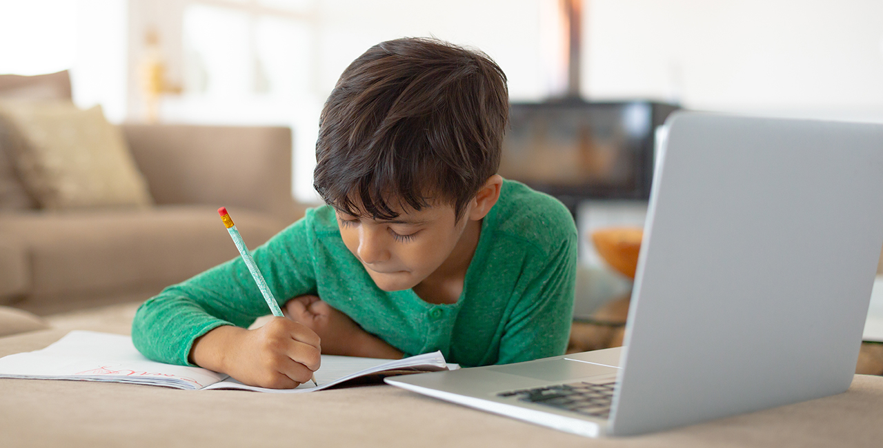 Young child using laptop to do homework